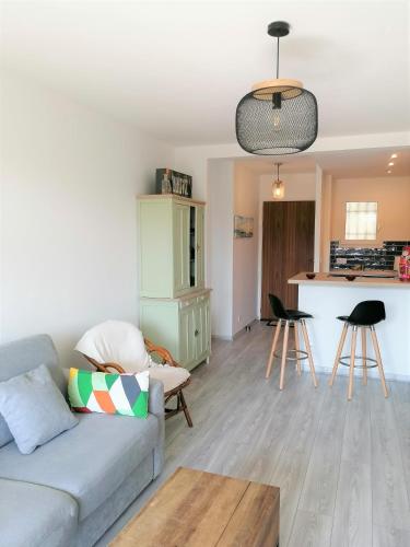 un salon avec un canapé et une cuisine dans l'établissement Le Cosy, proche plage, base nature, tout à pied, à Fréjus