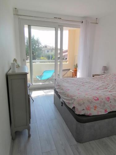 une chambre avec un lit et une porte coulissante en verre dans l'établissement Le Cosy, proche plage, base nature, tout à pied, à Fréjus