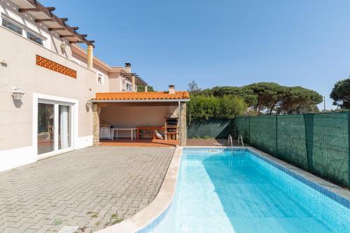 a villa with a swimming pool and a house at Vila Pérola da Lagoa in Vau
