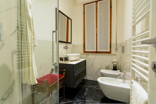a bathroom with a sink and a toilet and a mirror at Casa Giorgiana in Buonconvento