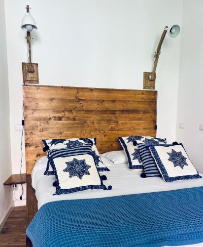 a bed with blue and white pillows on it at About Italy Holiday Rooms and Apartments in Portovenere
