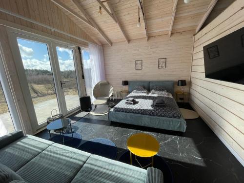 a bedroom with a bed and a couch and a tv at GLAMP GLAMOUR***** in Kowale Oleckie