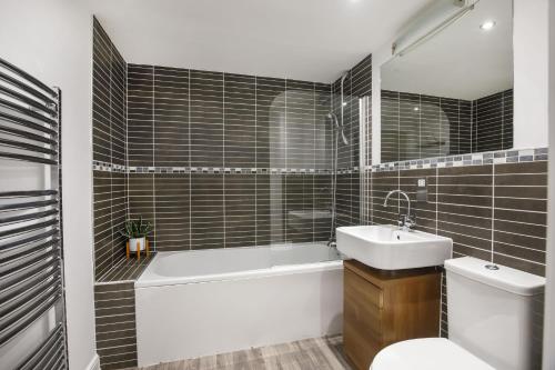 ein Badezimmer mit einer Badewanne, einem Waschbecken und einem WC in der Unterkunft Dixon's Yard, Luxurious City Centre Apartment in York