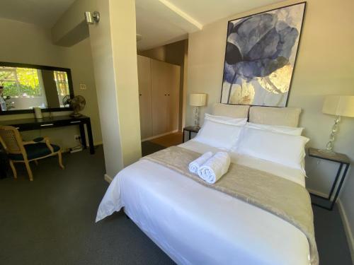 a bedroom with a large bed with two towels on it at Vredelust Cottage in Bellville