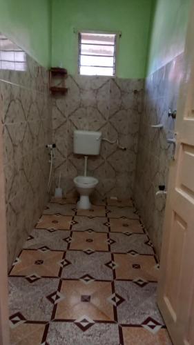een badkamer met een toilet en een tegelvloer bij JAHA in Lamu