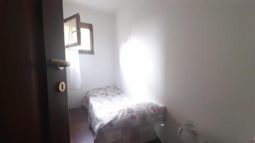 een kleine slaapkamer met een bed en een wastafel bij Lucca Guest House in Lucca