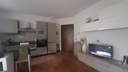 een woonkamer met een keuken en een tv. bij Lucca Guest House in Lucca