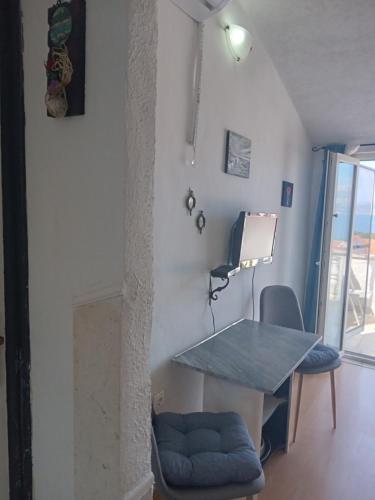 einen Tisch und Stühle in einem Zimmer mit Fenster in der Unterkunft Apartment Ma're in Supetar