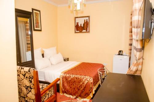 a hotel room with a bed and a table and a chair at ROYAL SHALOM HOTEL in Lusaka