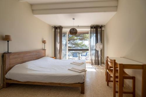 a bedroom with a bed and a desk and a window at Le Pescadou in Martigues