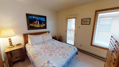 een slaapkamer met een bed en een lamp en twee ramen bij Grandview 12 Townhouse With High Speed Wifi in Red River