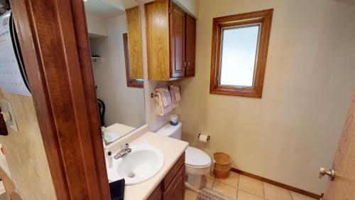 een badkamer met een wastafel en een toilet en een raam bij Grandview 12 Townhouse With High Speed Wifi in Red River