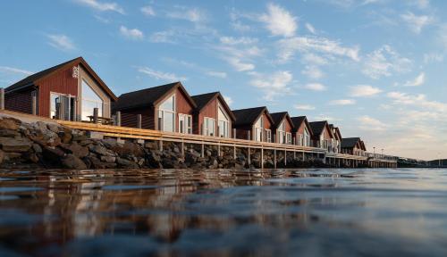 a row of houses on a pier next to the water at Norsk Havbrukssenter - Rorbuer in Brønnøysund