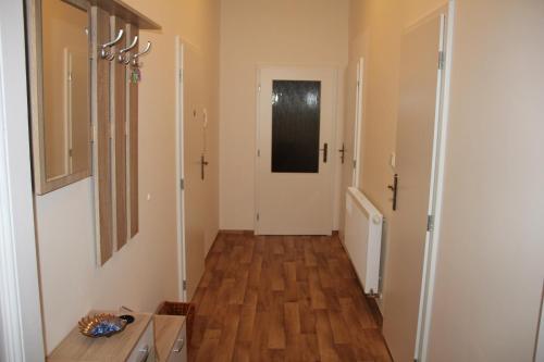 a hallway with wooden floors and a white door at Apartman Relax Olomouc in Olomouc