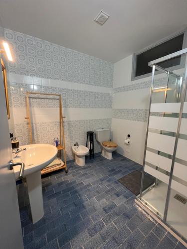 łazienka z 2 toaletami, umywalką i prysznicem w obiekcie La casa de mamá w mieście Lorca