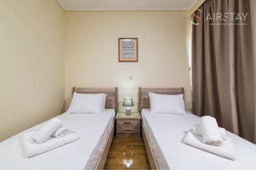 2 camas individuales en una habitación con ventana en Thresh Apartments Airport by Airstay, en Spáta