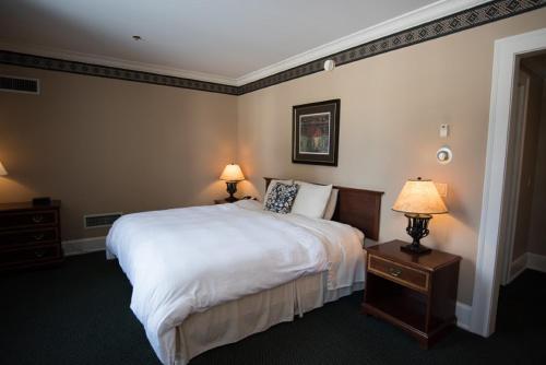 a hotel room with a large bed and two lamps at The Bertram Inn at Glenmoor in Canton