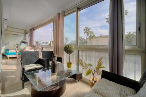 d'un salon avec une table en verre et des fenêtres. dans l'établissement Le Jak - 2 Pièces - Loggia - VCA, à Cannes