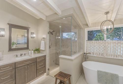 een badkamer met een bad, een douche en een wastafel bij 3874 Mission Fields home in Carmel