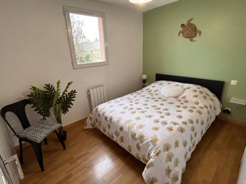 - une chambre avec un lit et une plante en pot dans l'établissement Charmante maison aux sables 6 personnes, à Olonne-sur-Mer