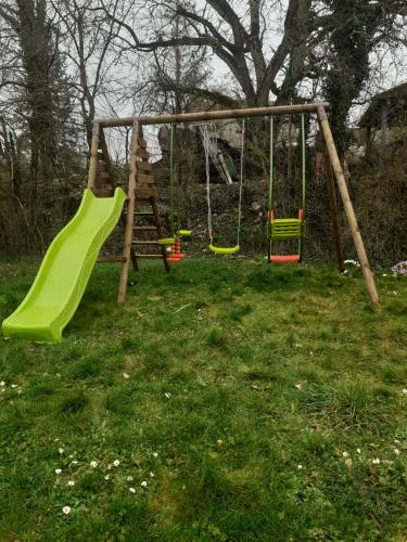 a playground with a green slide in the grass at Le val mousset in Beurville