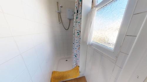 ein kleines Bad mit einem Fenster und einer Dusche in der Unterkunft F38 Barton, Riviere Towans in Hayle