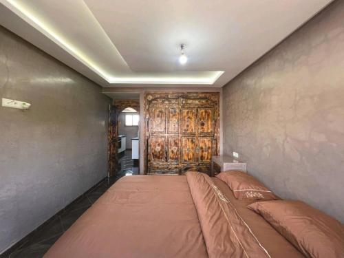 sypialnia z łóżkiem i drewnianymi drzwiami w obiekcie Les jardins berbères d'Agadir w mieście Agadir