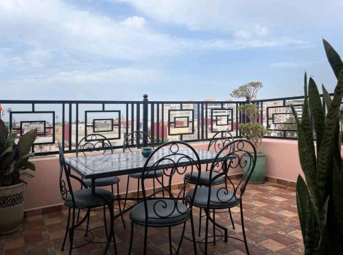 y balcón con mesa de patio y sillas. en Les jardins berbères d'Agadir en Agadir