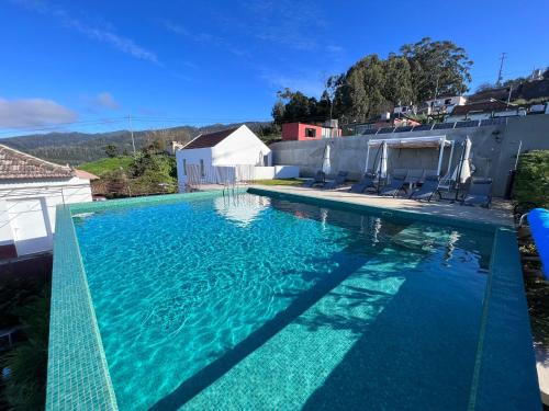 a swimming pool with blue water on a house at House Nobrega of Madeira in Arco da Calheta