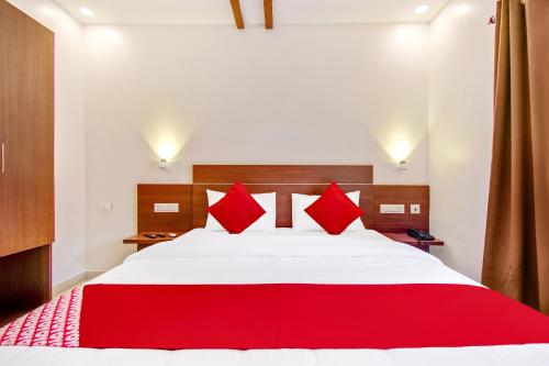 a red and white bed in a room at Hotel Resida Elite Service Apartments Near Manipal hospital in Bangalore