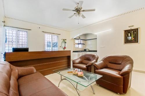 a living room with two leather chairs and a table at Hotel Resida Elite Service Apartments Near Manipal hospital in Bangalore
