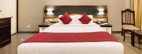 a bedroom with a large bed with red pillows at Lemongrass inn munnar in Anachal