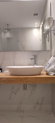 a bathroom with a white sink and a mirror at Mary Hotel in Limenas