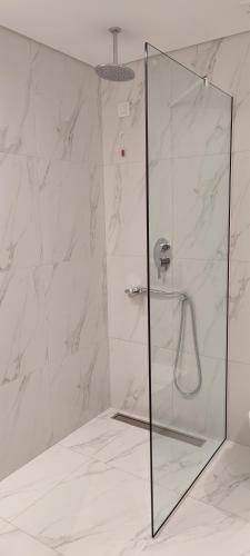 a shower with a glass door in a bathroom at Mary Hotel in Limenas