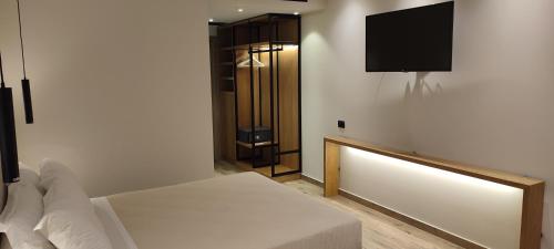a bedroom with a bed and a tv on a wall at Mary Hotel in Limenas