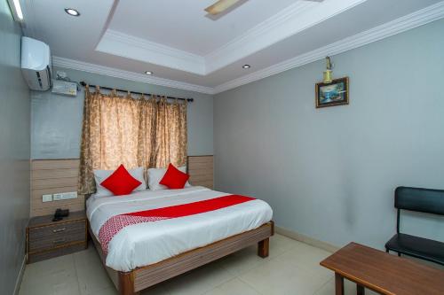 a bedroom with a bed with red pillows and a window at Flagship White Fort Near Lalbagh Botanical Garden in Bangalore