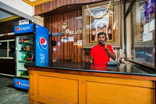 a man standing at a bar talking on a microphone at Hotel O Royal Residency Near Hare Krishna Hill in Jālahalli
