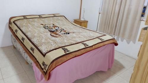 Una cama con una manta encima. en Chalet Pan de Azucar en Cosquín