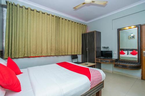 a bedroom with a bed with red pillows and a mirror at Flagship White Fort Near Lalbagh Botanical Garden in Bangalore