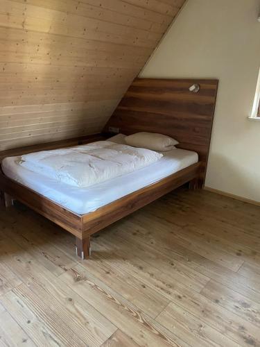 a bed in a room with a wooden floor at Landgasthof Hirsch in Remchingen