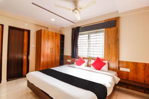 a bedroom with a large bed with red pillows at Capital O N R Residency in Bengaluru