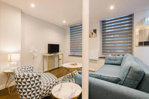 a living room with a blue couch and chairs at CitySpace Leicester Square in London