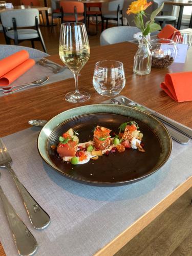 a plate of food on top of a table with wine glasses at Norsk Havbrukssenter - Rorbuer in Brønnøysund