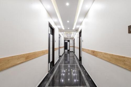 an empty corridor in a building with a hallway at Capital O Regal suites in Bengaluru