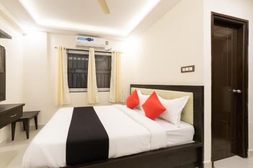 um quarto com uma cama com almofadas vermelhas em Super Capital O Choice Regal Suites Near Ragigudda Sri Prasanna Anjanayeswamy Temple em Bangalore