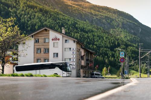 un autobús está estacionado frente a un edificio en Hotel Mountime, en Täsch