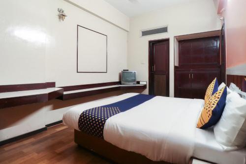 ein Schlafzimmer mit einem Bett und einem TV. in der Unterkunft Oyo Yatra Inn in Bangalore