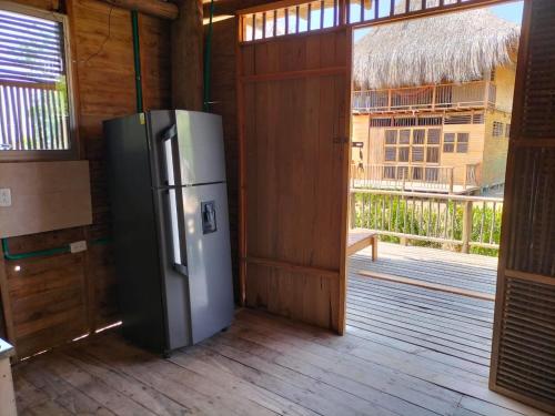 a refrigerator in a room with a door and a balcony at Bungalow Palmar del Viento by AMAUNA in Moñitos