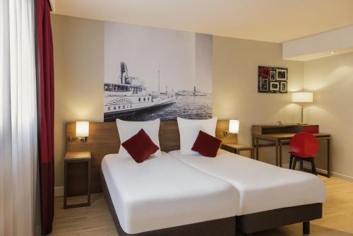 a hotel room with a bed with a boat in the background at Adagio Original Thoiry Genève in Thoiry