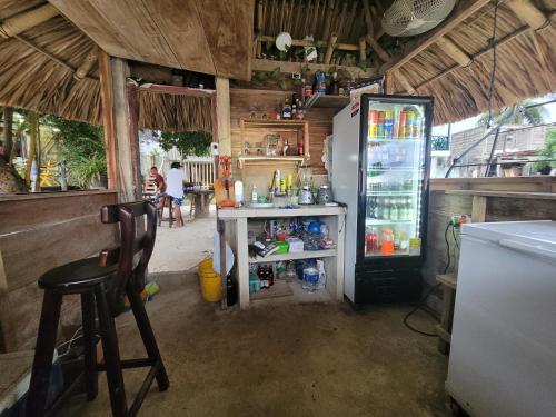 a kitchen with a refrigerator and a table and a chair at Hostel Rincon del mar Ebenezer in San Onofre